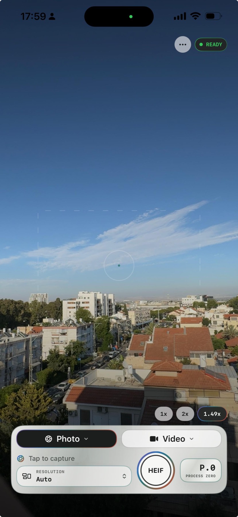 PureShot no-filter iPhone camera live viewfinder over a city and sky