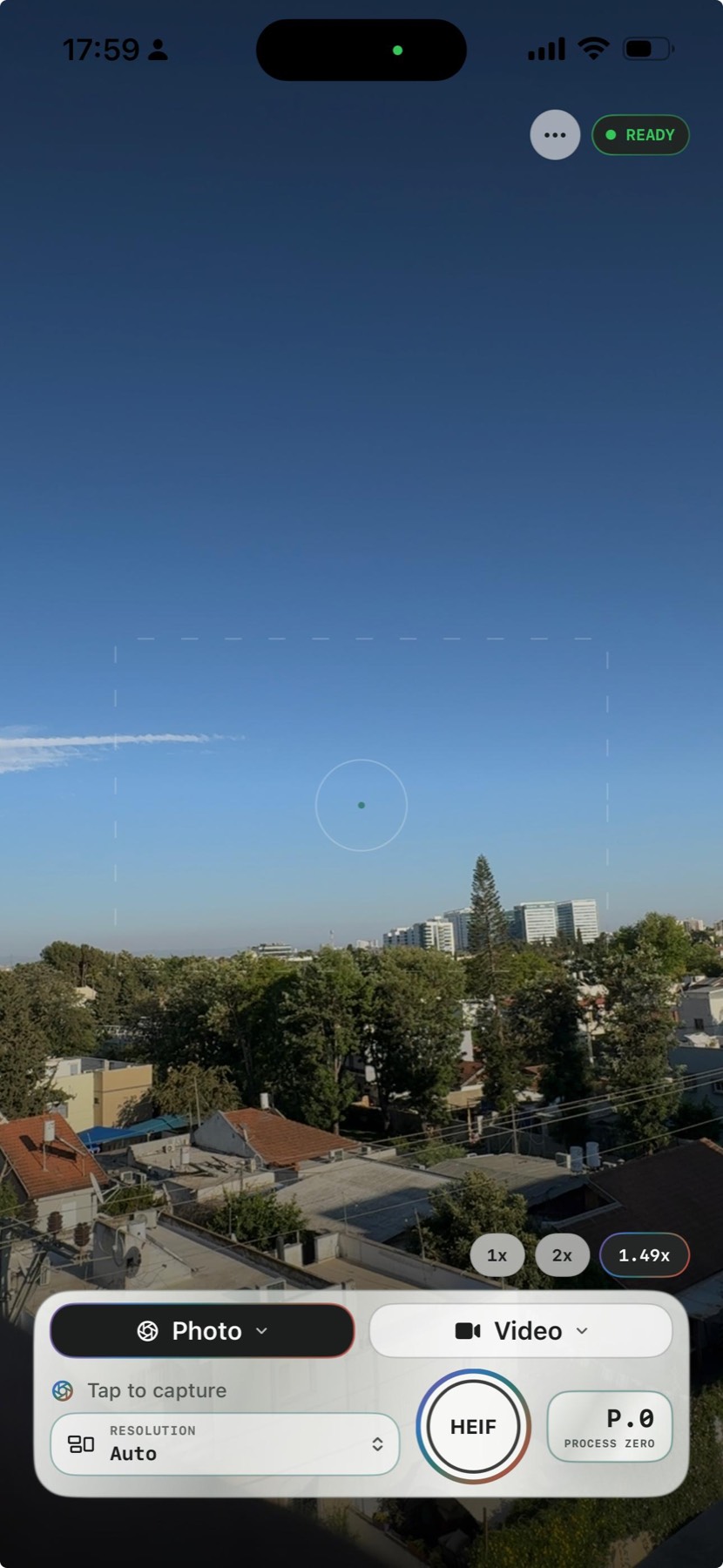 PureShot no-filter iPhone camera viewfinder over a skyline and blue sky